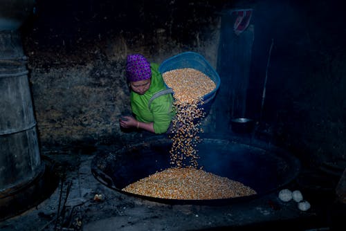 Woman Pouring Corn Kernels on a Wok