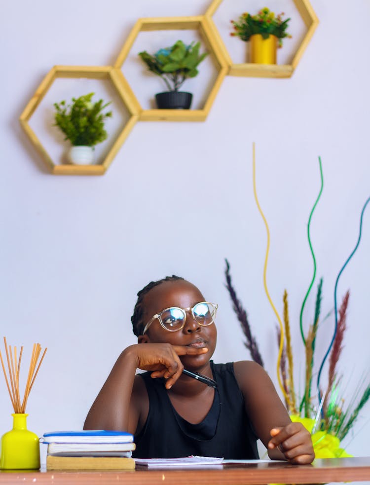 A Young Student Pondering At Her Study Table