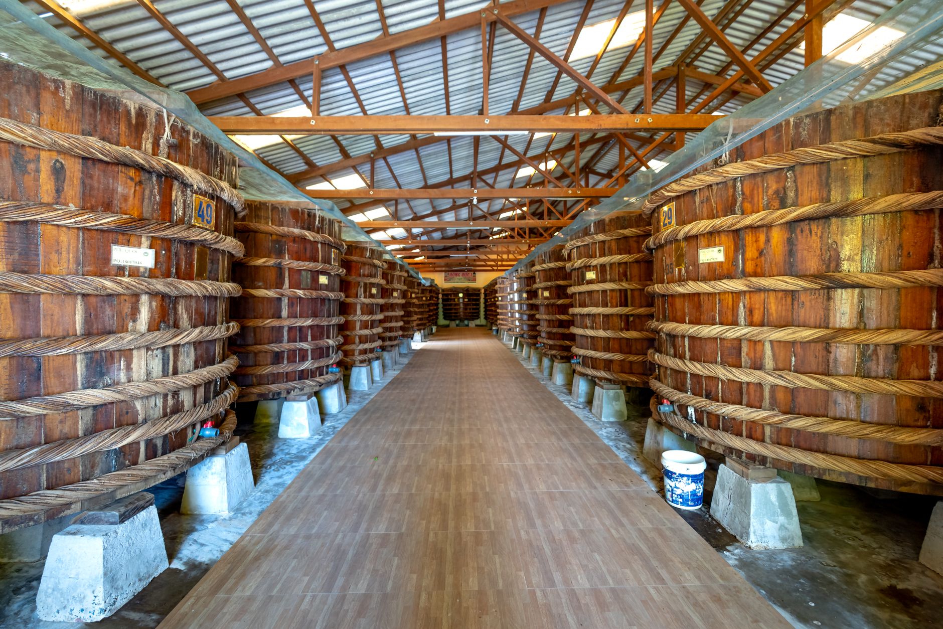 Inside a fish sauce factory in Phu Quoc, Vietnam, showcasing large wooden vats used in traditional production.
