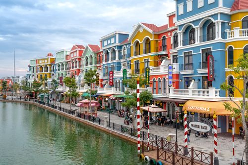 Free Vibrant, colorful buildings line a serene canal, evoking a Venetian feel in this urban scene. Stock Photo