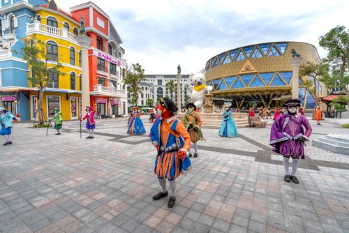 Free Vibrant festival parade featuring dancers in traditional costumes in a colorful city square. Stock Photo