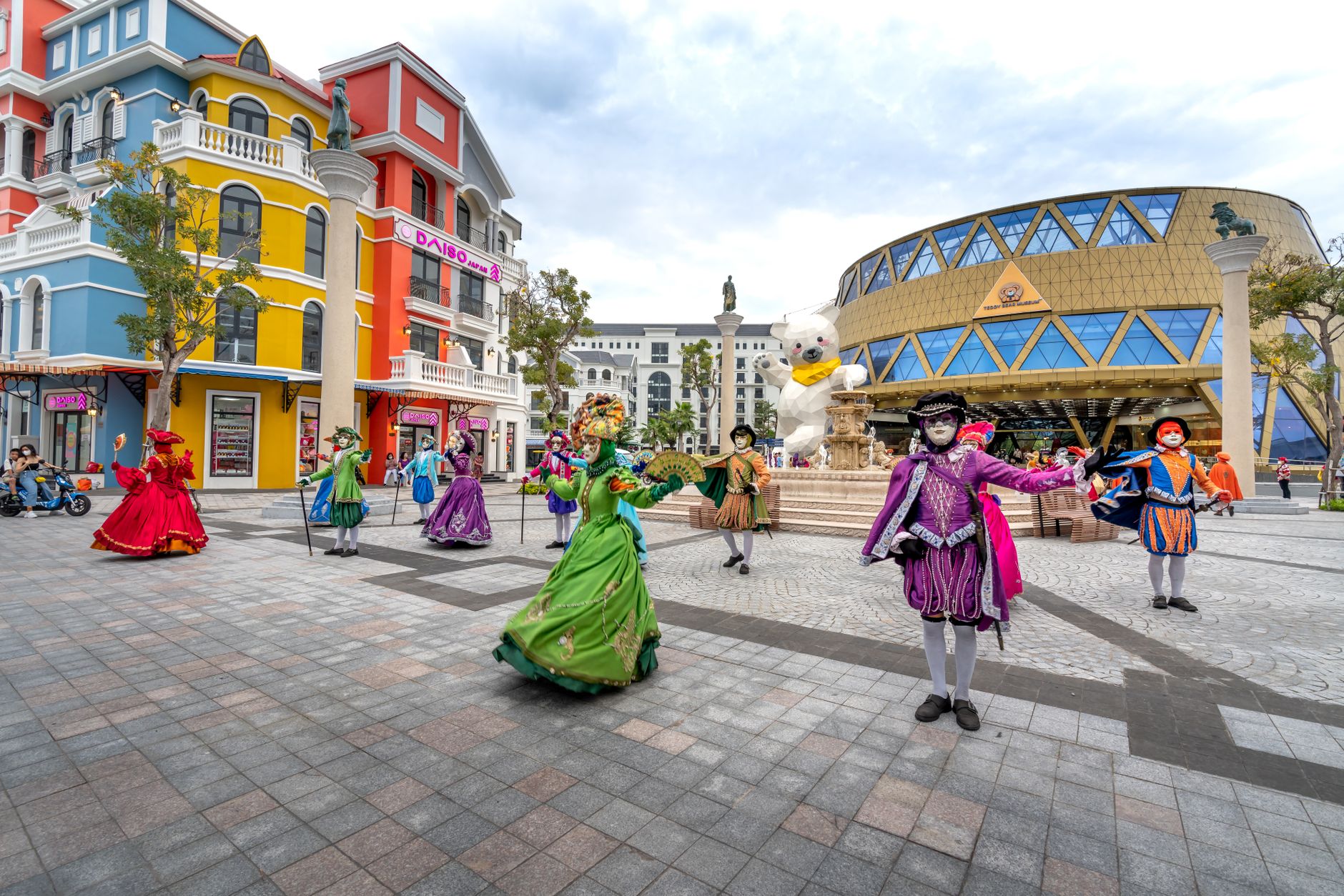 Vibrant masquerade performers in colorful costumes dancing on Phu Quoc street.