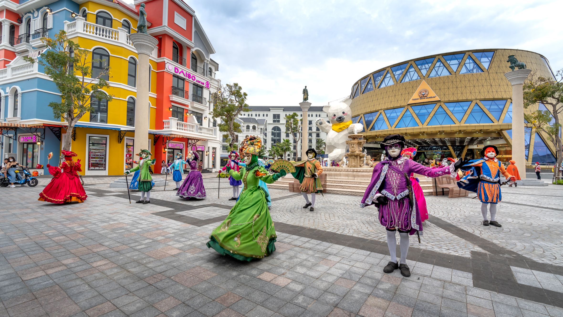 Vibrant masquerade performers in colorful costumes dancing on Phu Quoc street.