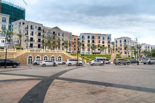 Free Urban scene featuring classic architecture and a town square with cars parked elegantly. Stock Photo