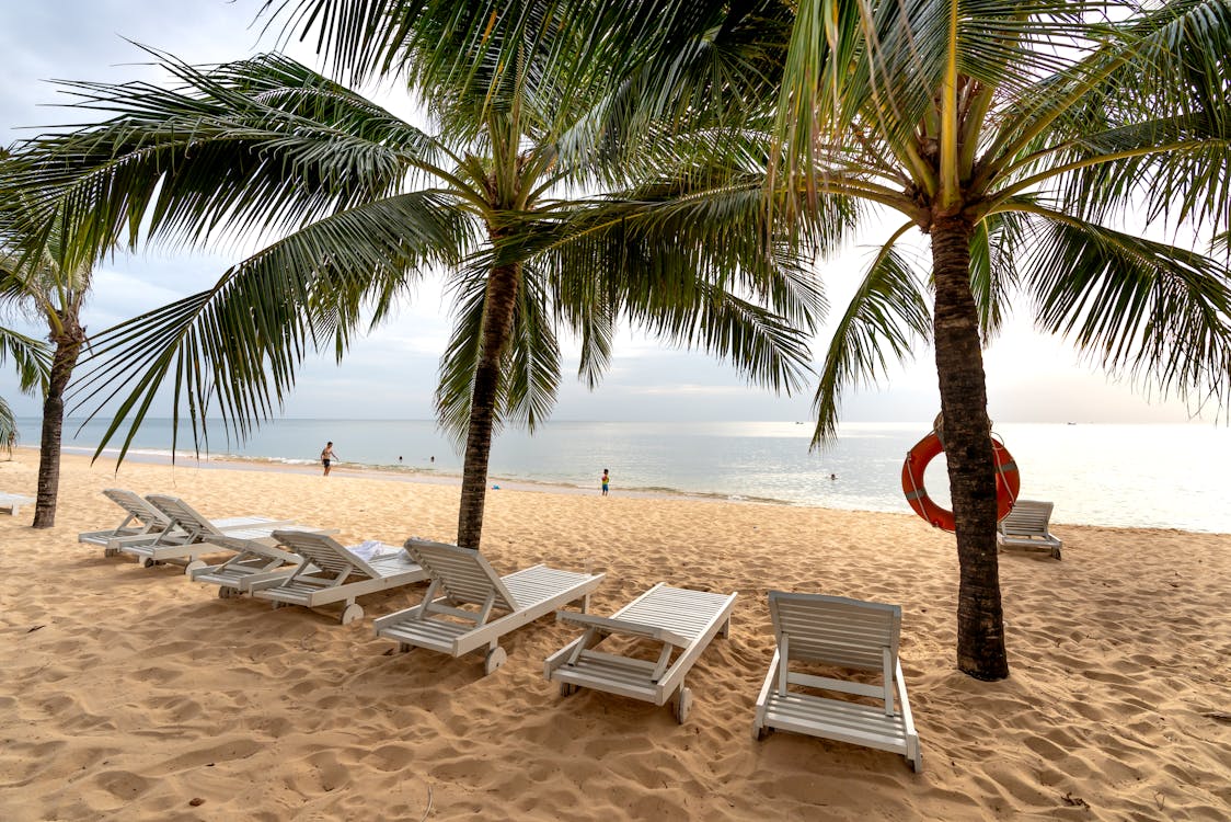 White Lounge Chairs on Beach