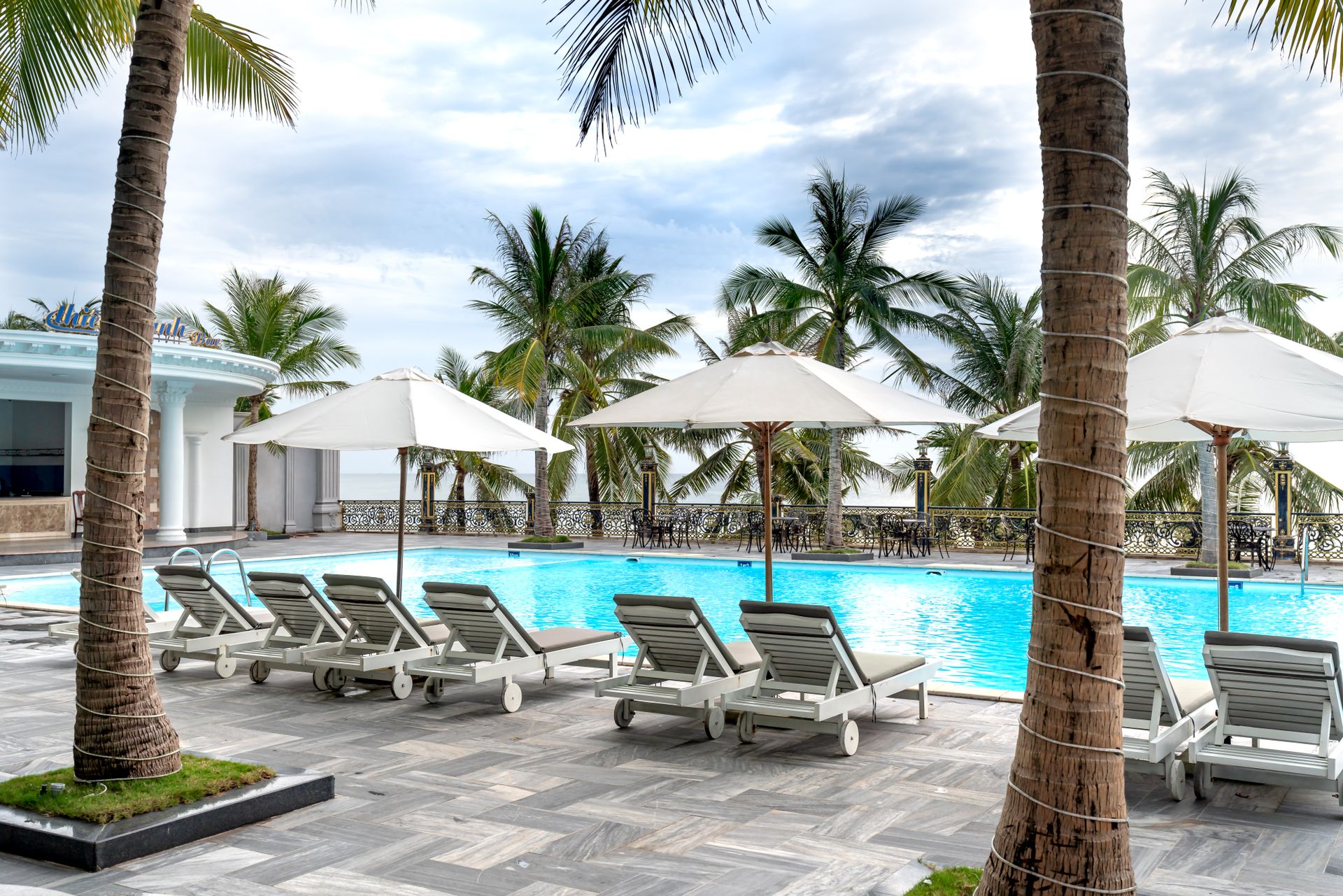 Discover relaxation and luxury at a tropical resort with poolside lounge chairs and palm trees.