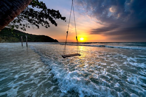 Бесплатное стоковое фото с берег моря, восход, деревянные качели