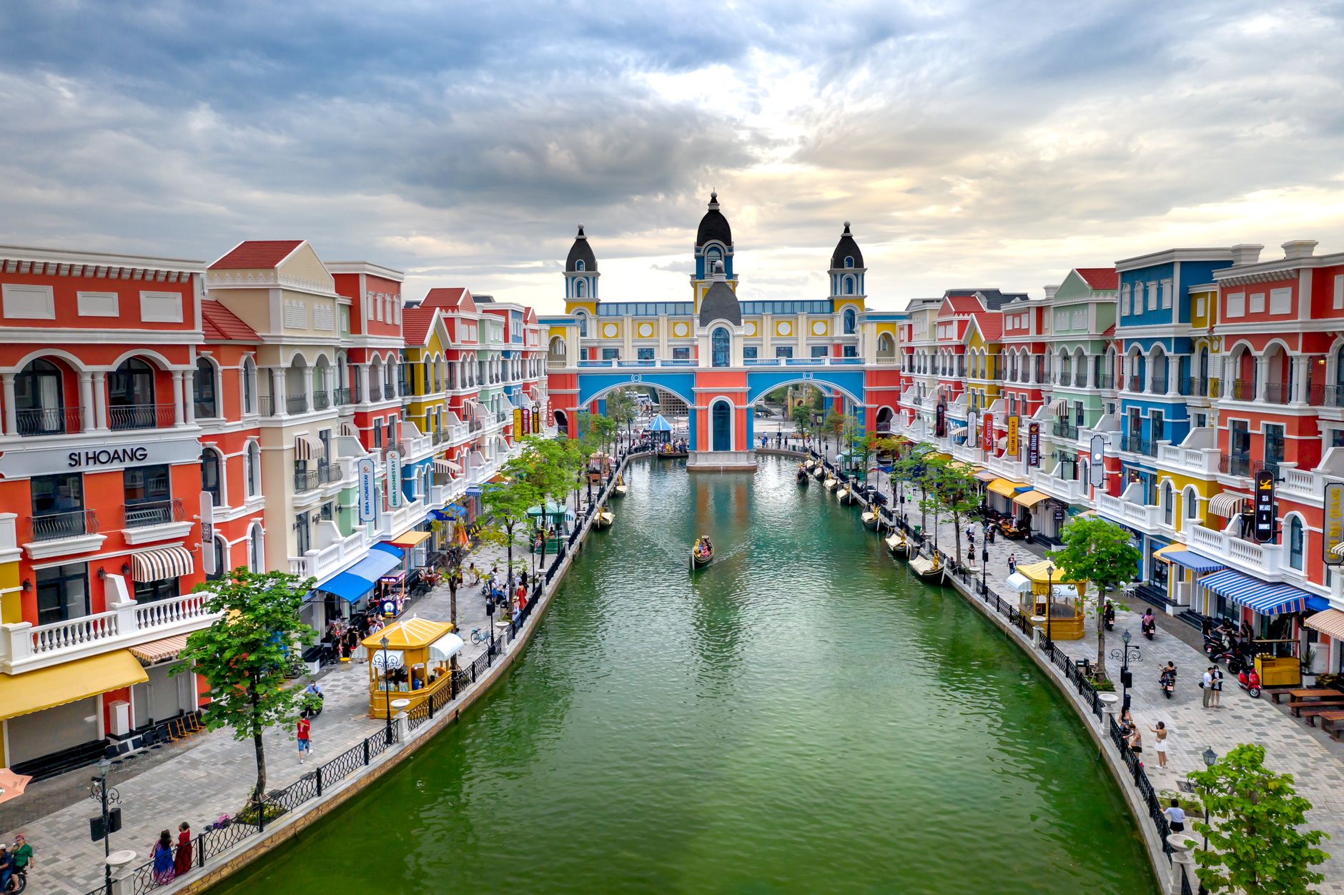 Vibrant European-style canal with colorful buildings and small boats.