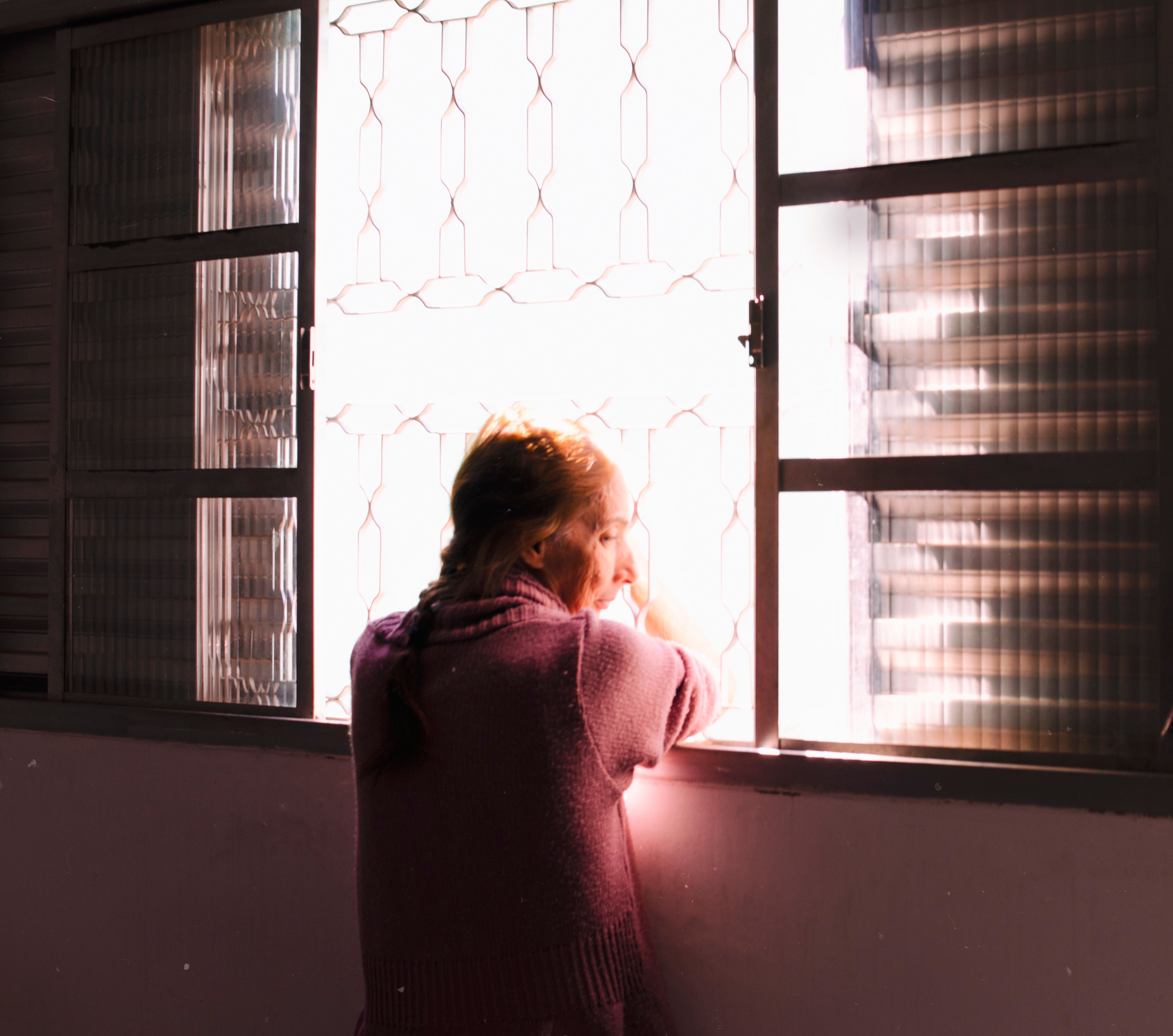 person sitting on a porch looking at the morning sky, soft golden light, peaceful expression
