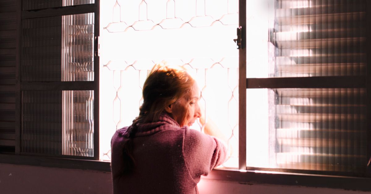 person sitting on a porch looking at the morning sky, soft golden light, peaceful expression