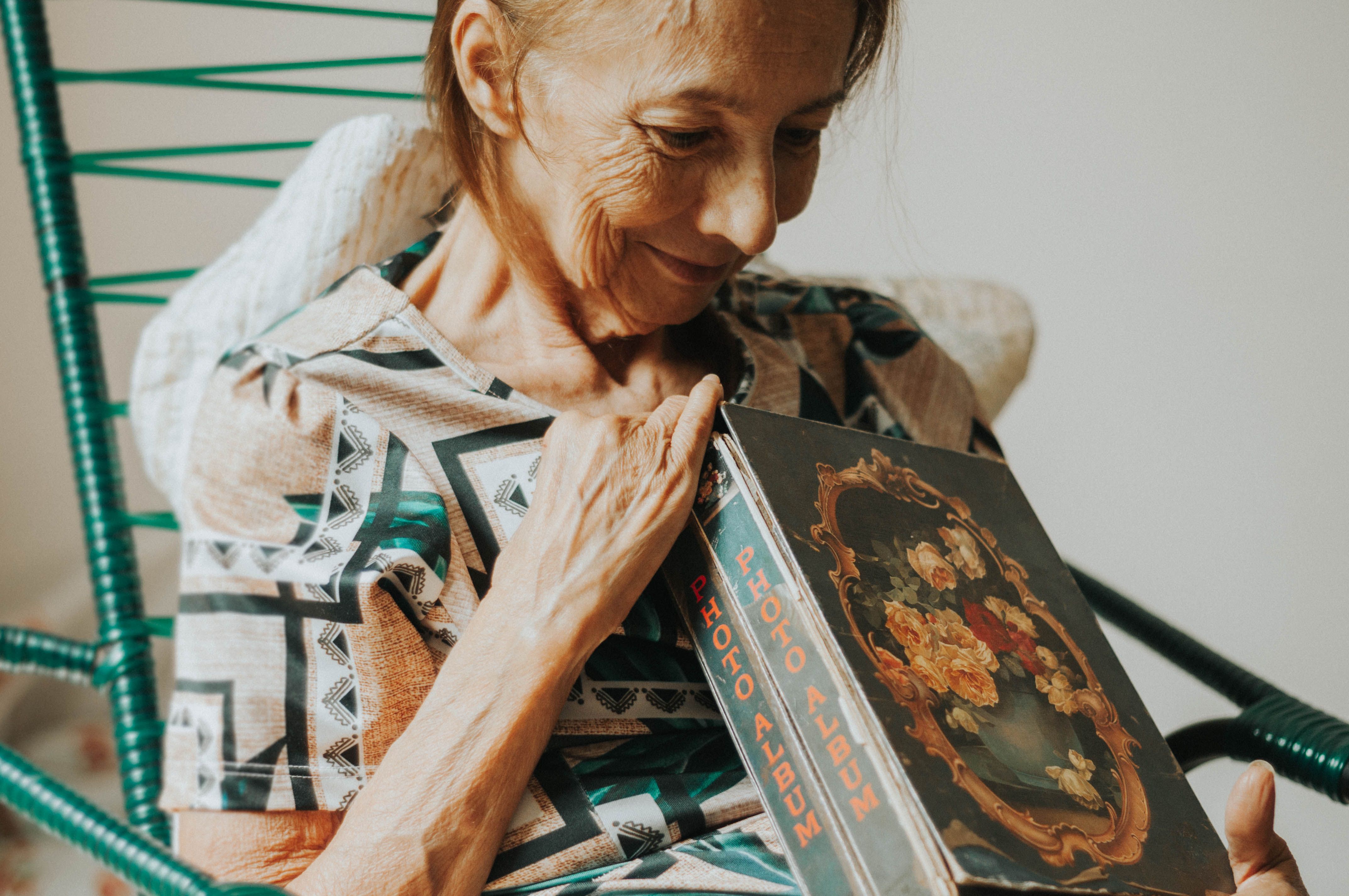 Older woman looking through a photo album at home