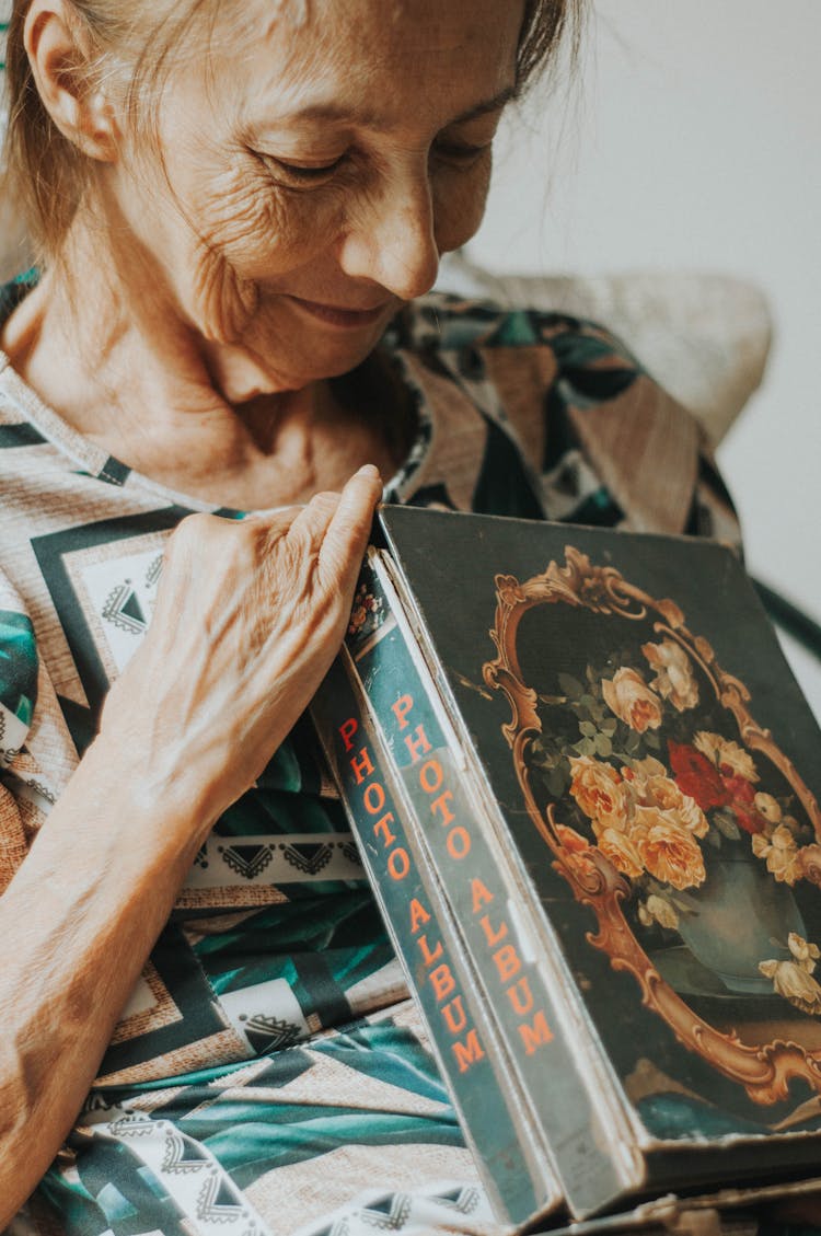 Smiling Elderly Woman Holding Vintage Photo Albums