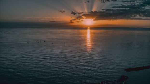 Beautiful sunset with warm hues over the calm waters of Igea Marina, Italy.