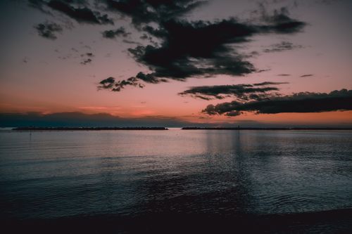 Free Captivating sunset view over tranquil sea with dramatic cloud formations. Stock Photo