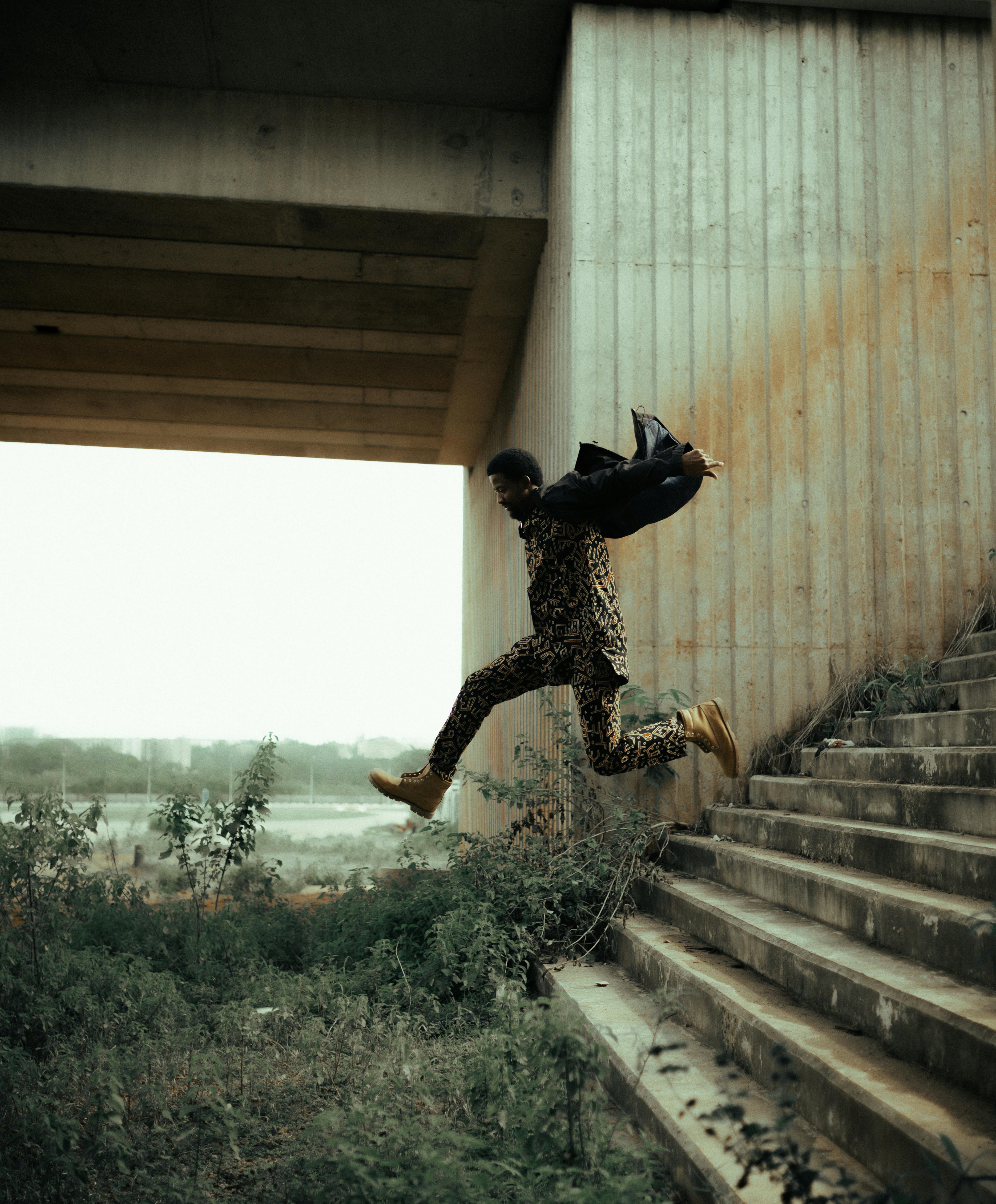 Dynamic shot of a man leaping mid-air in an urban setting, symbolizing freedom and energy.