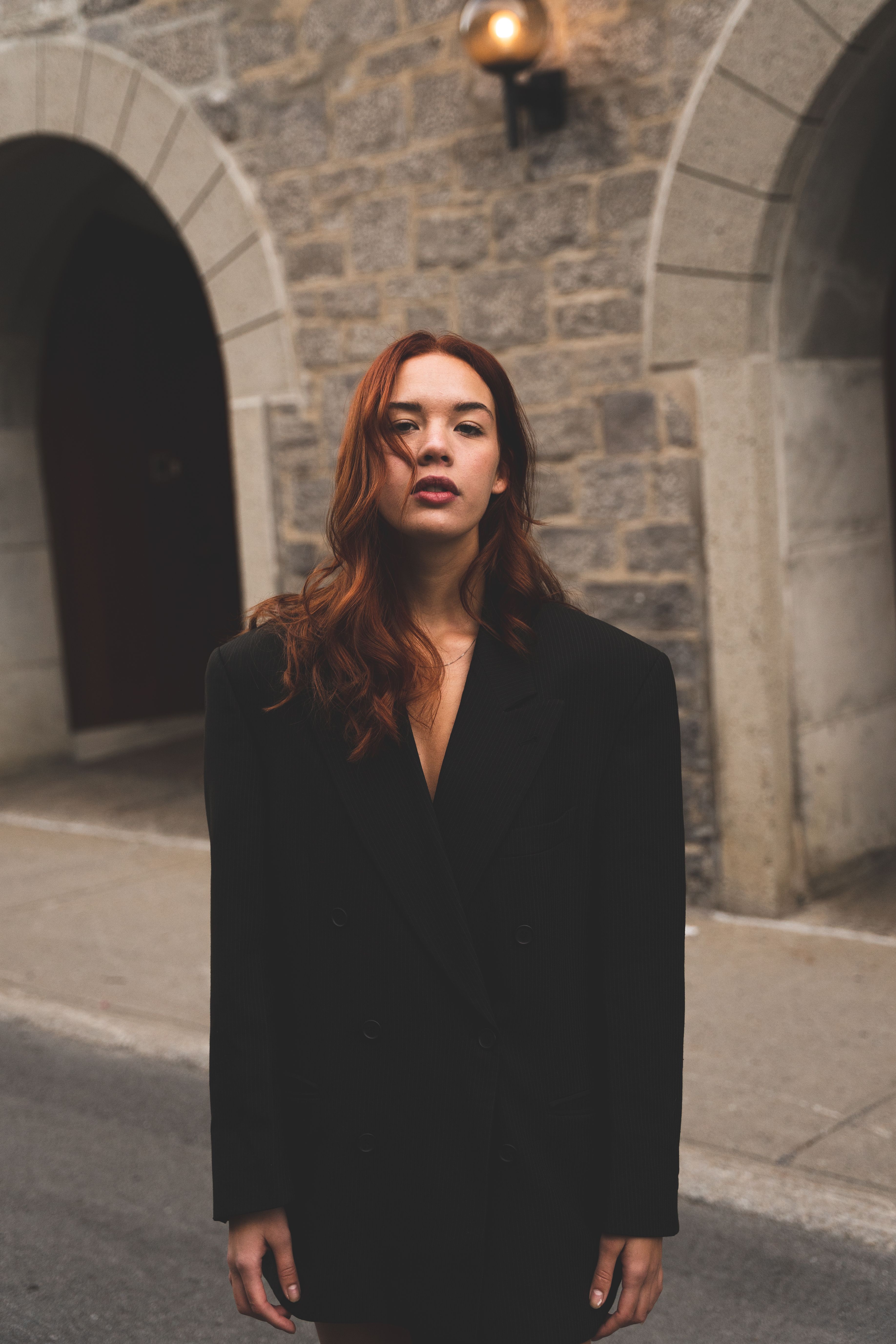 Fashionable woman in black coat standing outside in Montréal.