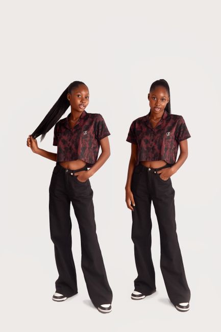 Young women in fashionable clothing posing in a studio with a white background.