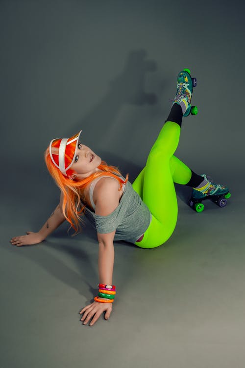 Woman in Gray Tank Top and Green Leggings Lying on Floor