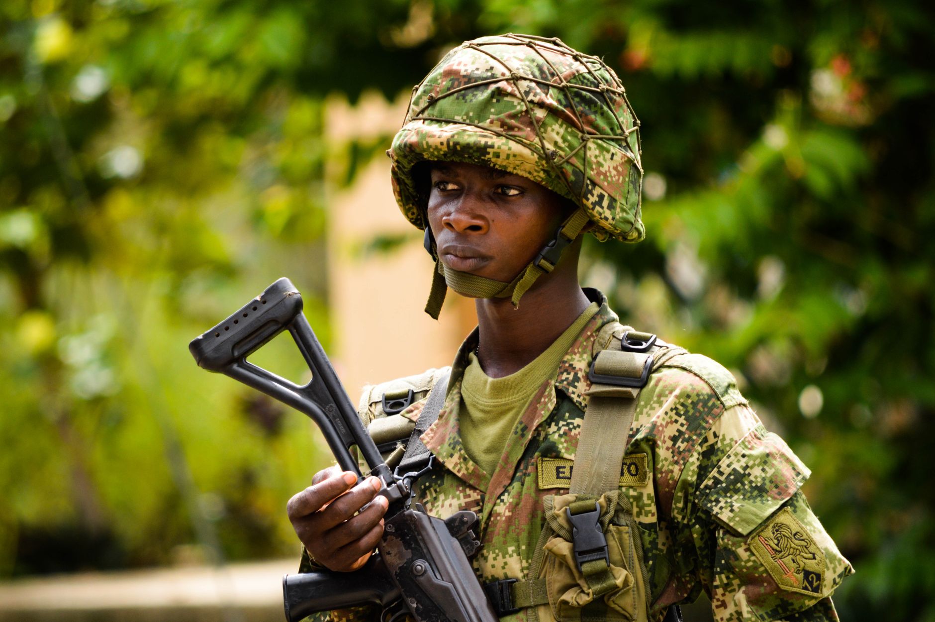 Soldier in Colombian military uniform holding a rifle, outdoors in Bojayá, Chocó, Colombia.