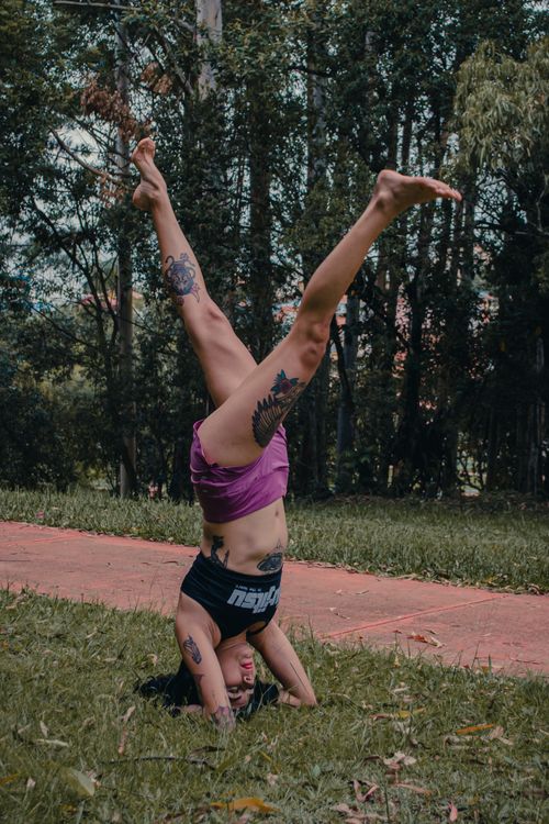 Free Tattooed woman doing a headstand outdoors, promoting a healthy lifestyle. Stock Photo