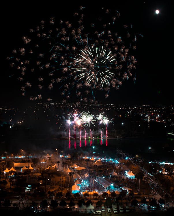 Bright Fireworks Display over City during Night Time