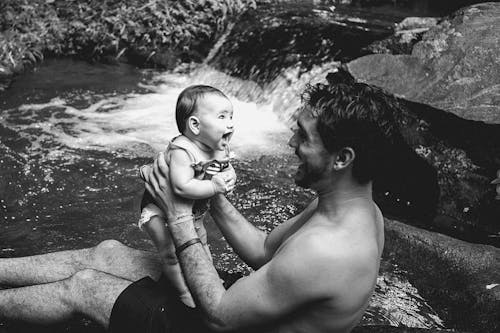 Black and White Photo of a Man Holding a Baby