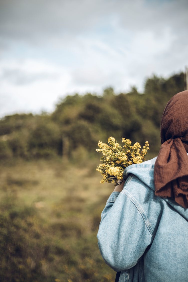 Back Of A Person Holding A Bunch Of Freshly Picked Wildflowers