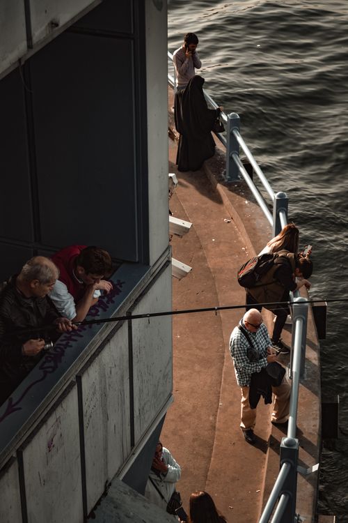 Free A group of people view the sea from a ship's deck, capturing a serene travel moment. Stock Photo