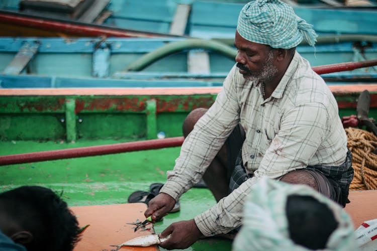 An Elderly Man Cleaning Fish