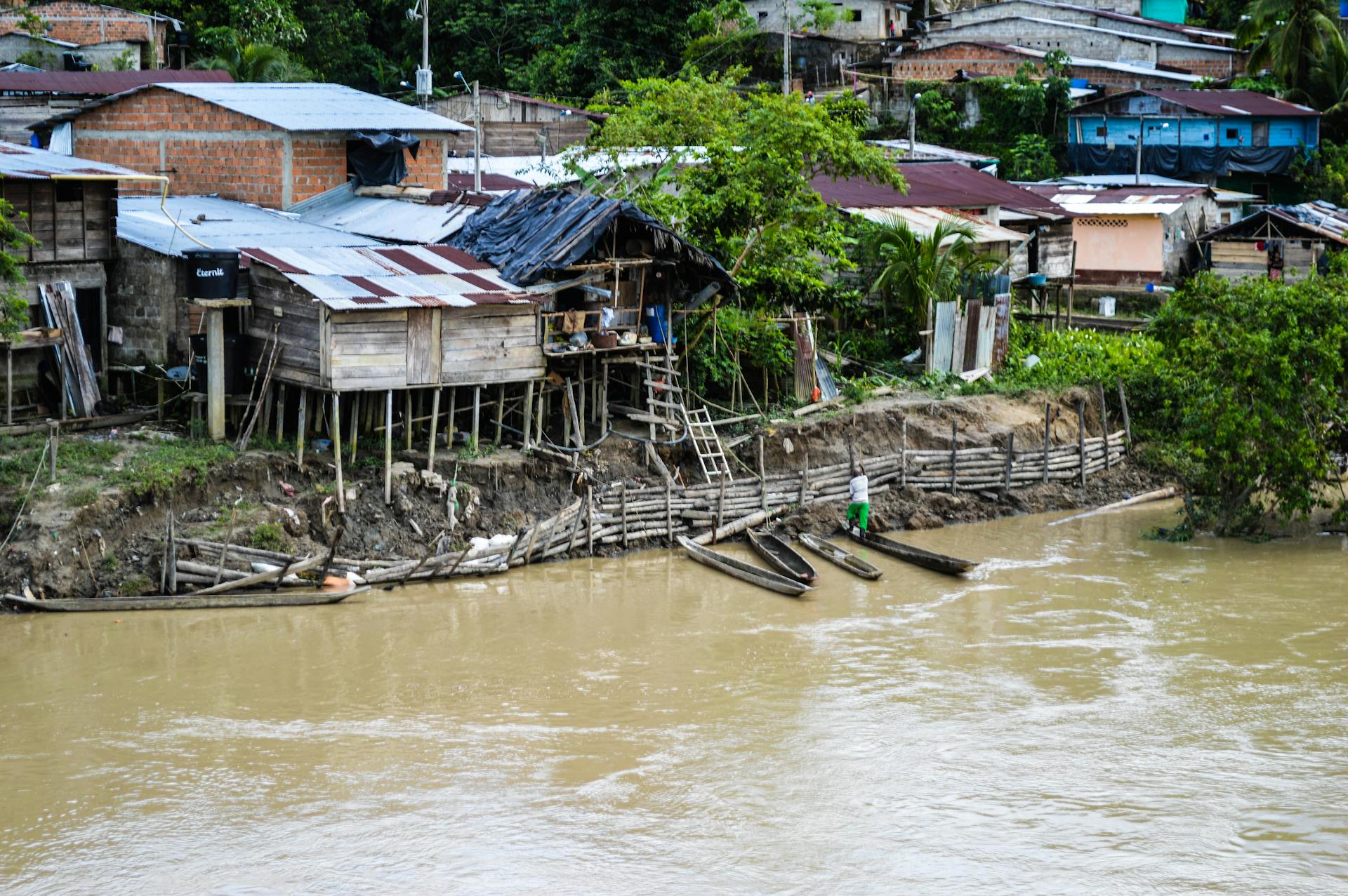 Rustic houses along a riverside in Puerto Nuevo, Chocó, Colombia, showcasing rural life.