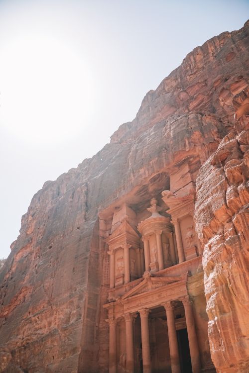 Free The Treasury carved into the rose-red cliffs of Petra, Jordan under a clear sky. Stock Photo