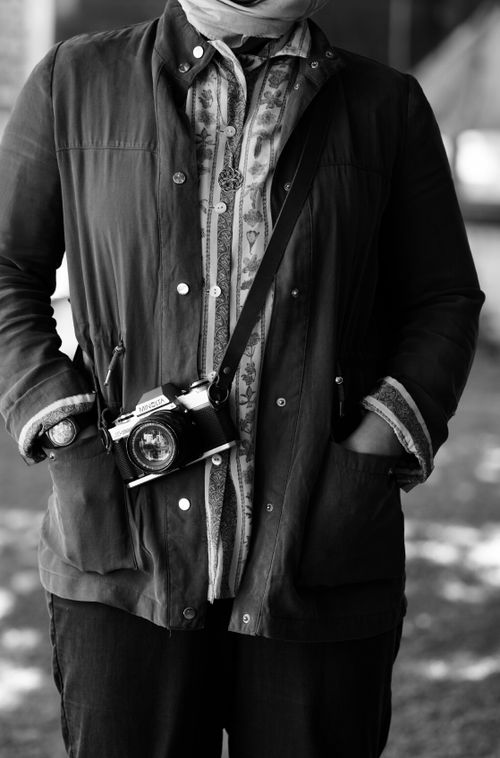 Free Black and white portrait of a person with a vintage camera around their neck. Stock Photo