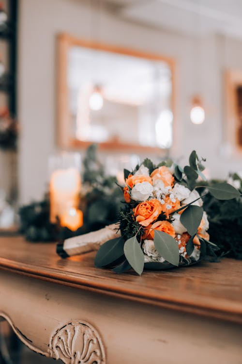 White and Orange Bouquet of Flowers on Brown Wooden Table