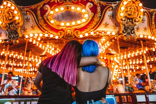 Two People Standing Beside the Carousel