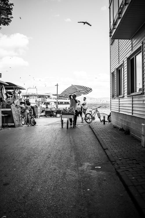 Black and White Photo of Men Setting up Stalls on Street