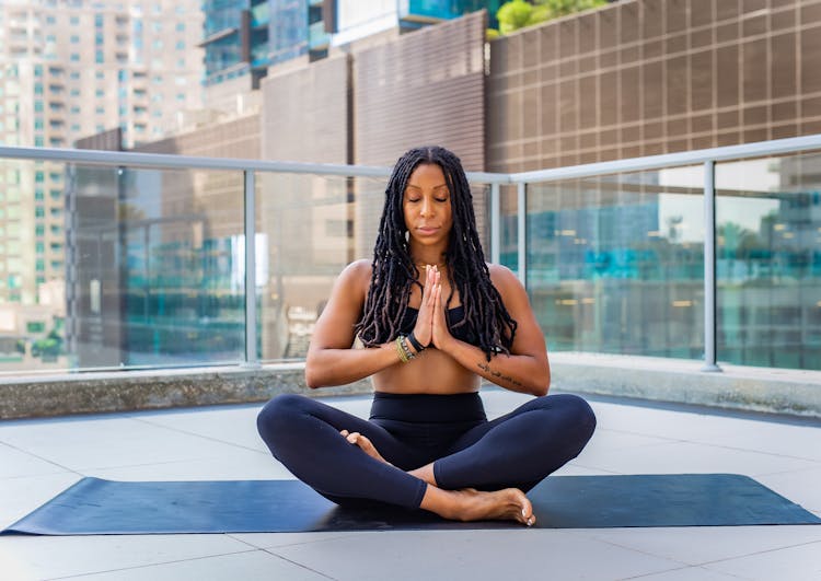 Woman Meditating On Mat