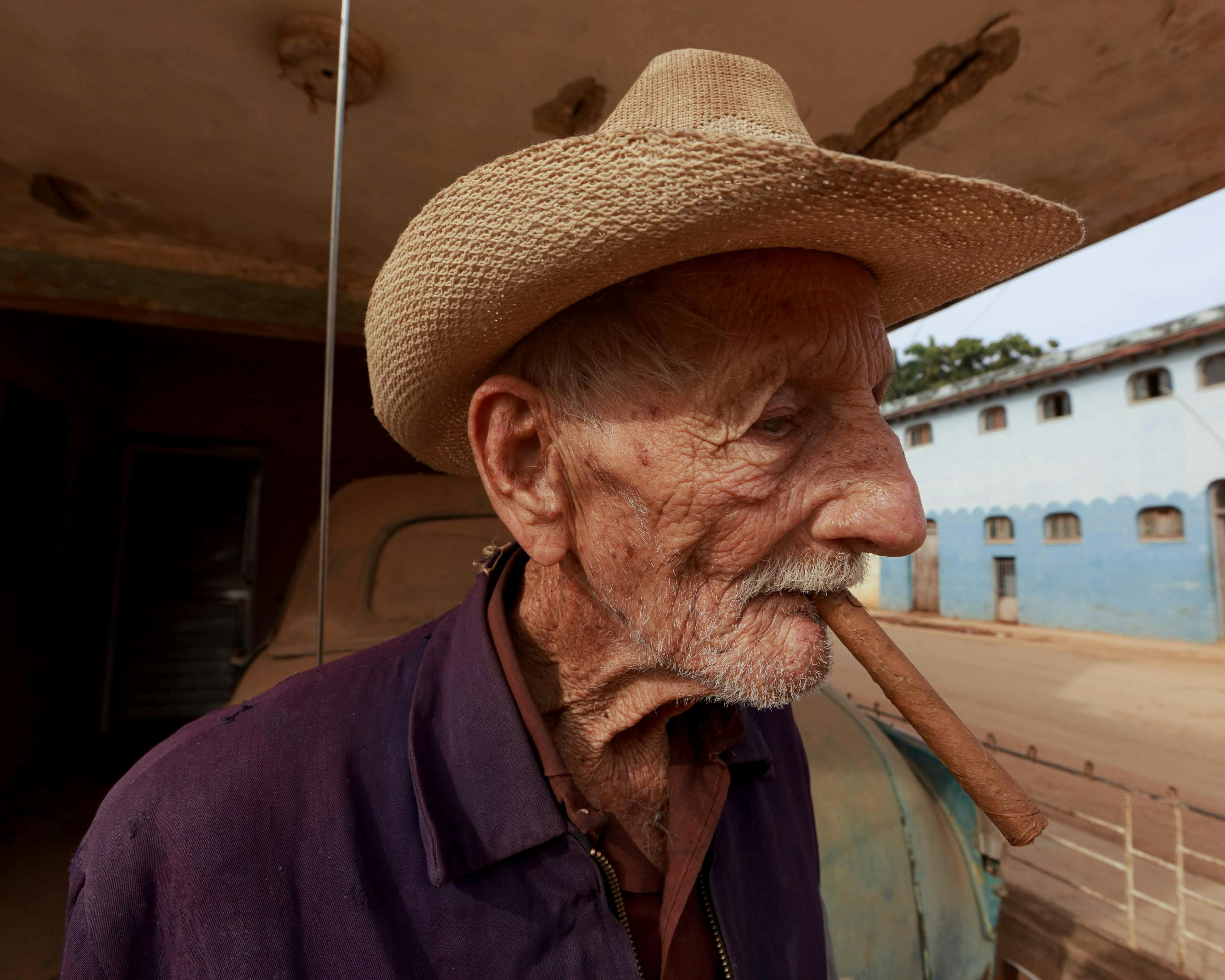 Elderly Man Smoking Cigar in Cowboy Hat · Free Stock Photo