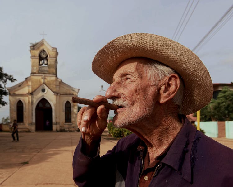 Man In Cowboy Hat Smoking A Cigar