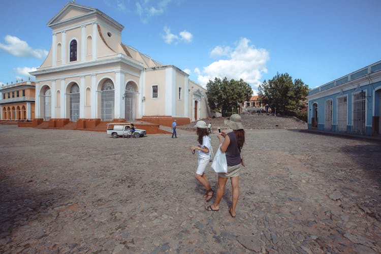 Women Wearing Sunhats Standing Near Church Of The Holy Trinity