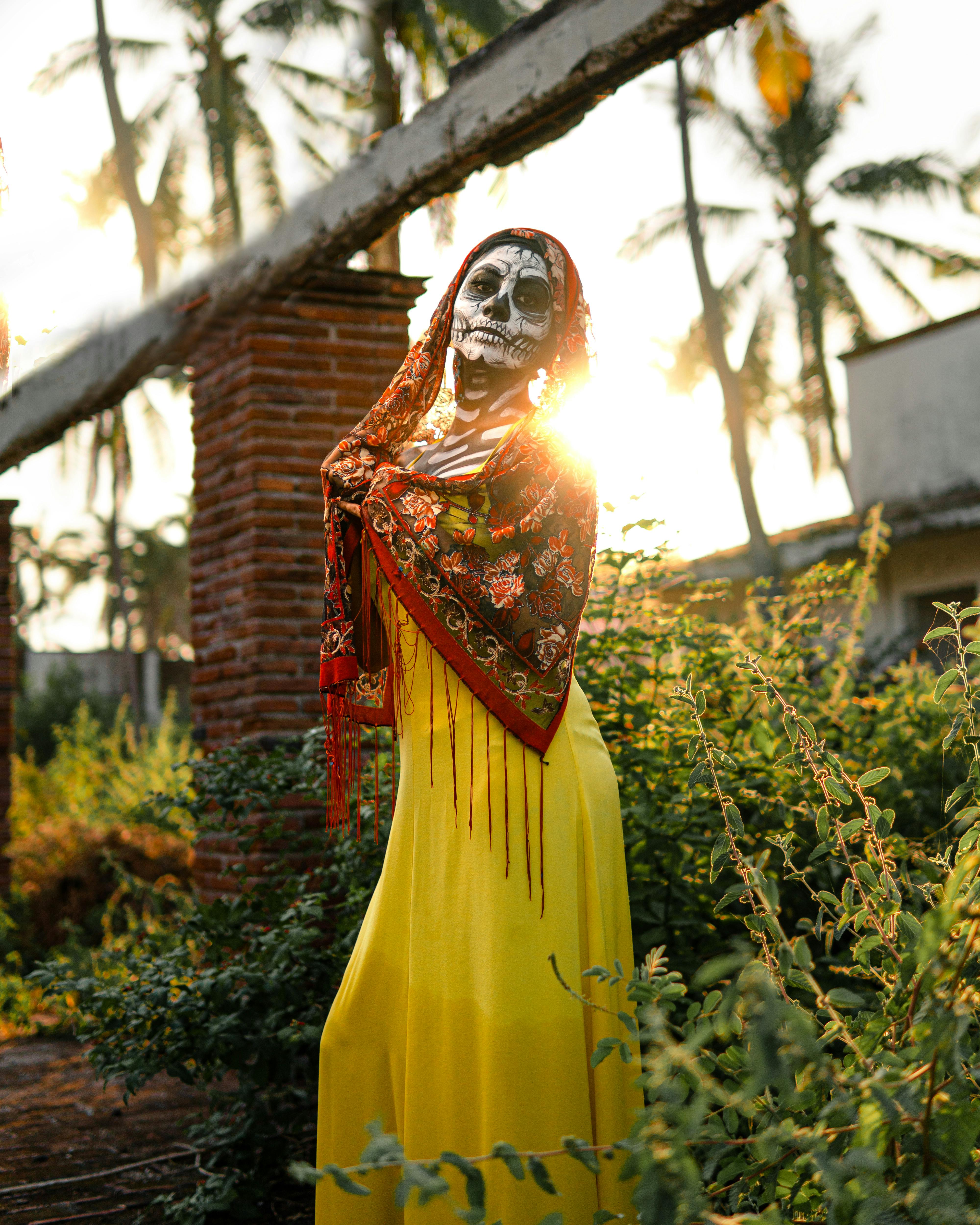 woman in yellow dress standing near green plants