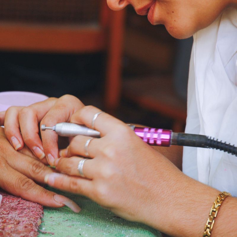 Nail technician shaping nails at Nail Studio
