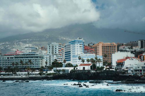 Free Scenic coastal view of Puerto de la Cruz, Spain with cityscape and ocean. Stock Photo