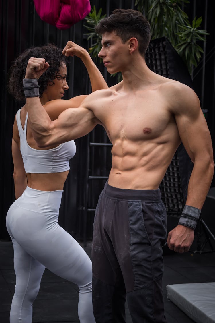 Man And Woman Flexing Their Muscles