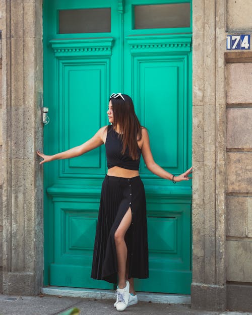 Woman in Black Crop Top and Long Skirt Posing on Wooden Doorway