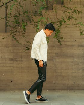 Fashionable man in denim jacket and leather pants walking outdoors in Ciudad de México.