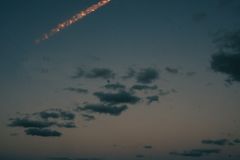 Stunning night view of a rocket launch over Cocoa Beach, Florida, showcasing a bright light trail above the ocean.