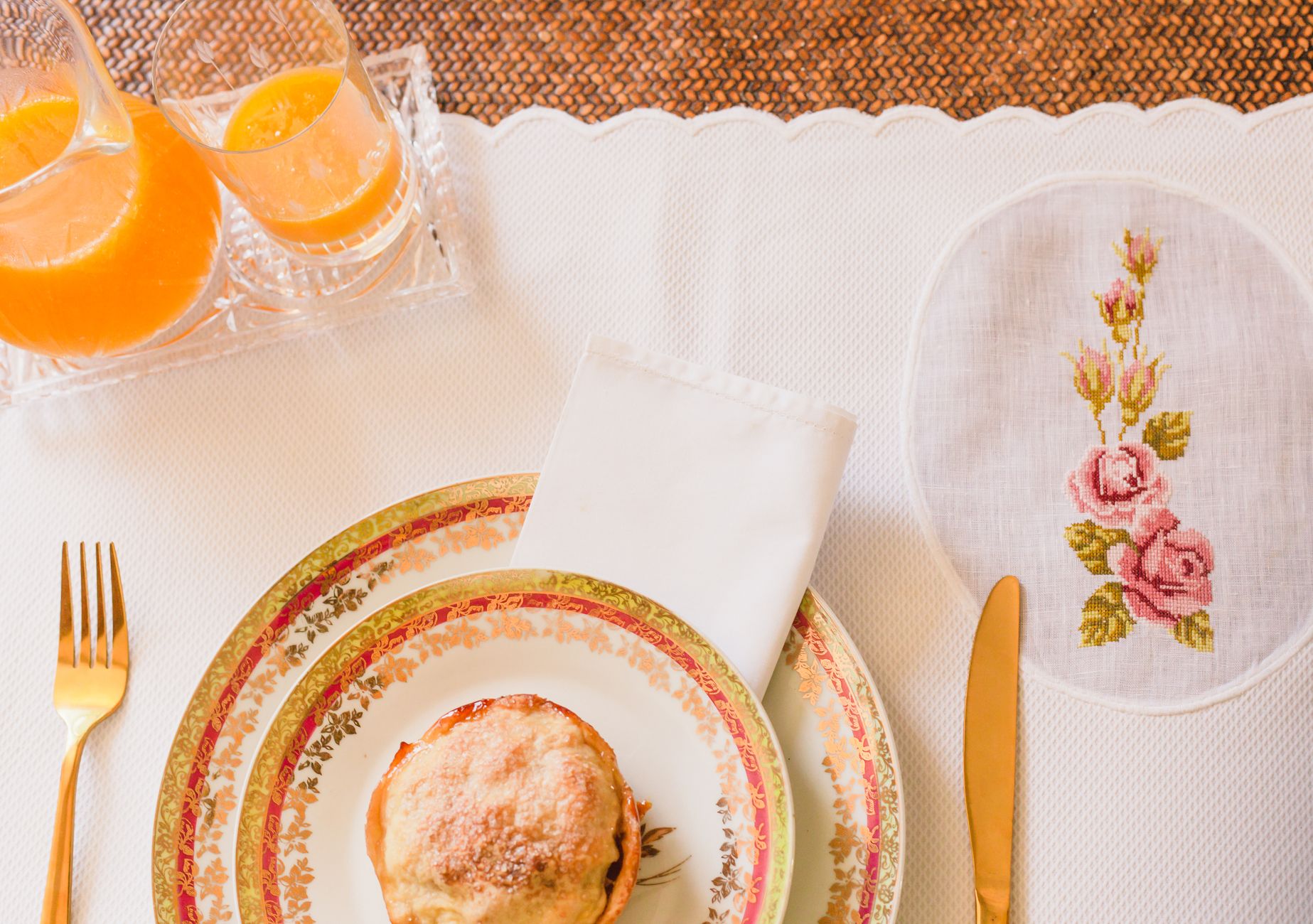 Top view of an elegant dining setup with orange juice and floral details, perfect for a cozy brunch.