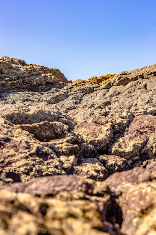 Low Angle Shot of Brown Rock Formation Under Blue Sky