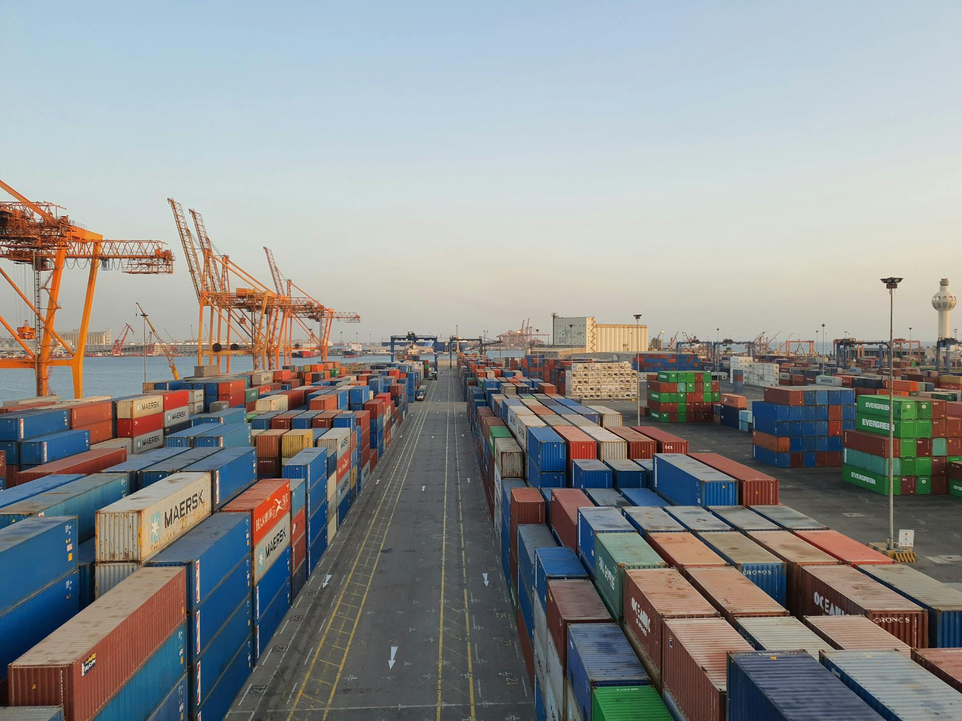 A bustling port scene with colorful cargo containers at sunrise. Ideal for logistics concepts.