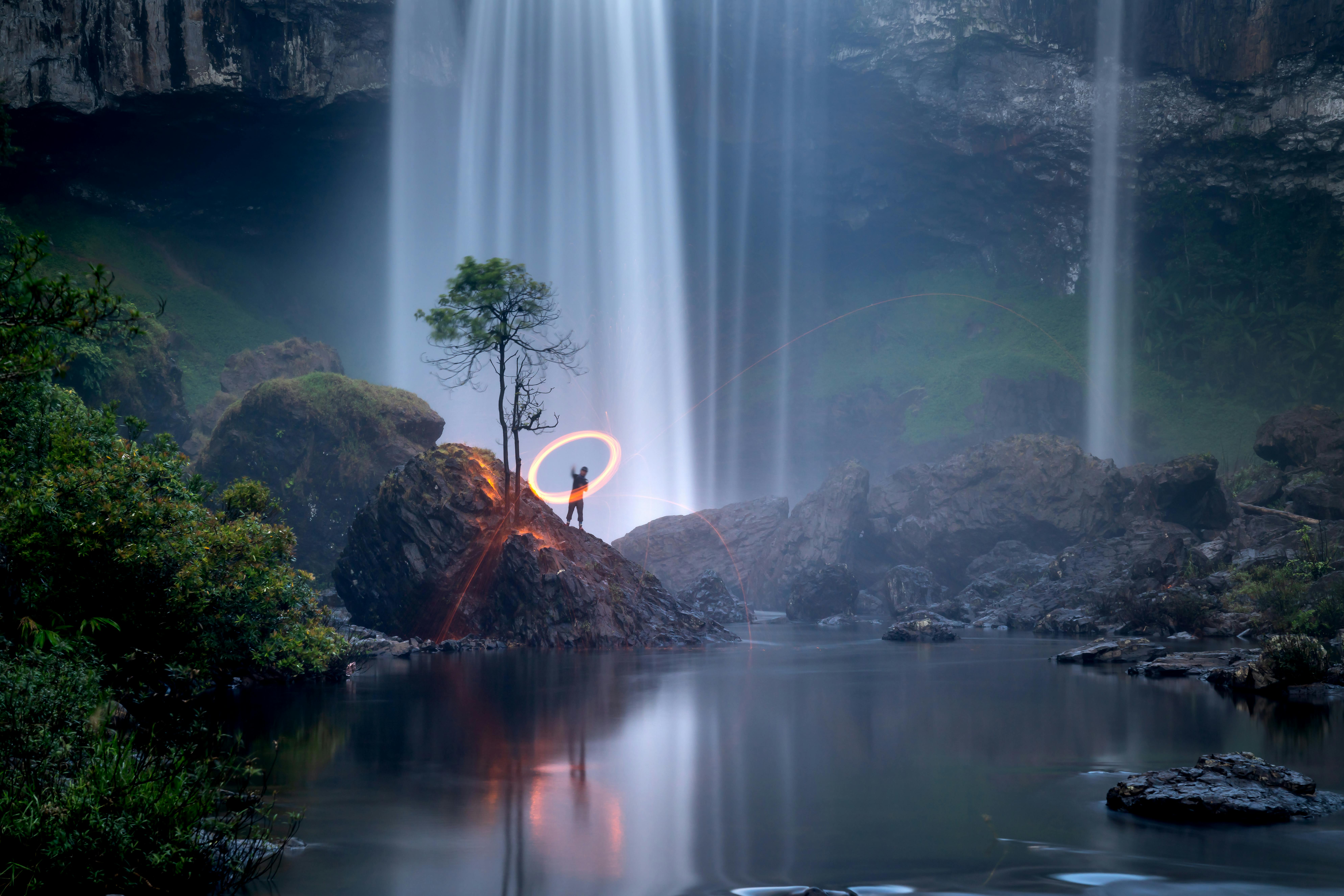 A stunning waterfall scene with artistic light painting in a mystical landscape.